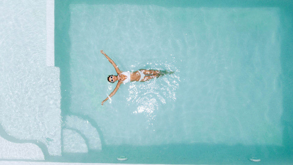 Femme dans une piscine extérieure chauffée, dans une maison de vacances à Perros-Guirec Femme se relaxant dans une piscine privée à Perros-Guirec